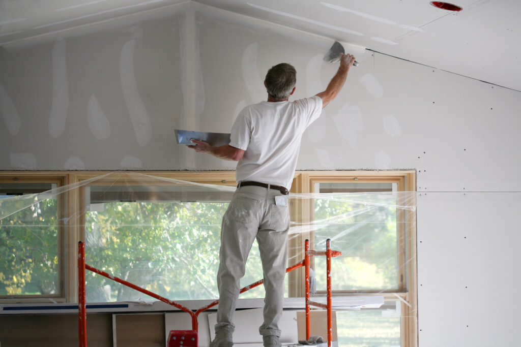 Madison Wisconsin Top Handyman applying mud to sheetrock on scaffolding